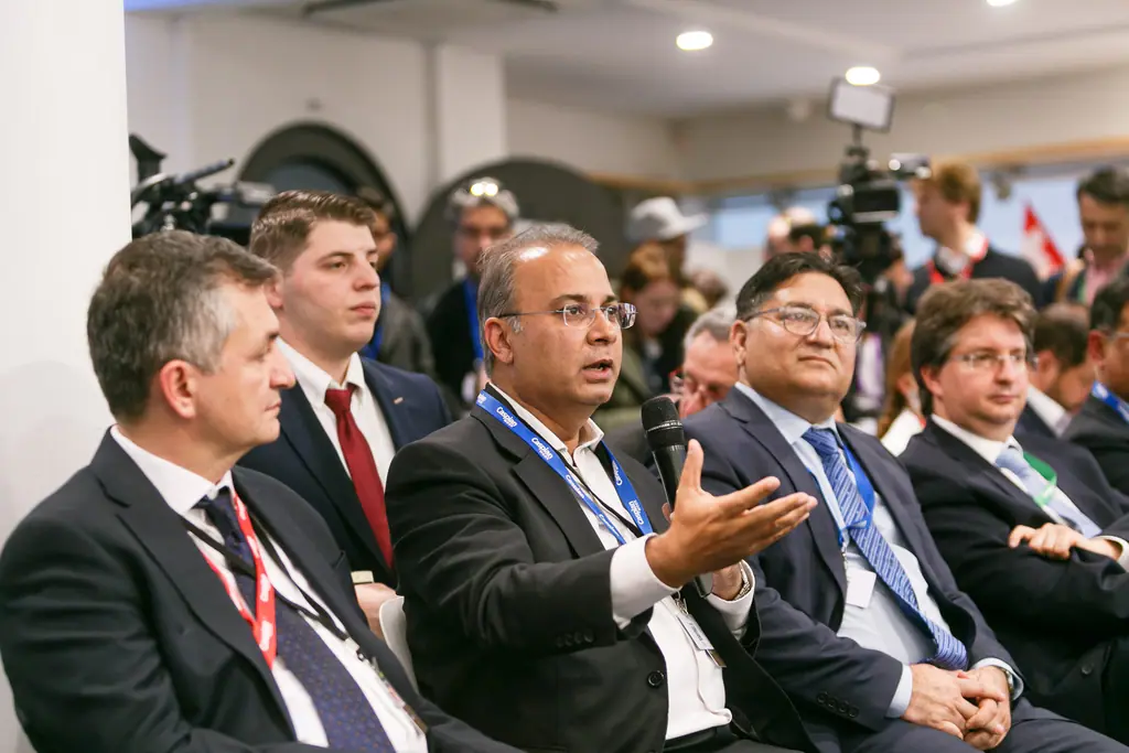A participant gestures as he joins the discussion from the front row
