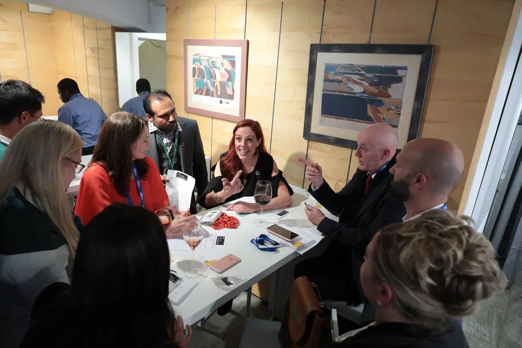 A small group talks around a table during an evening roundtable